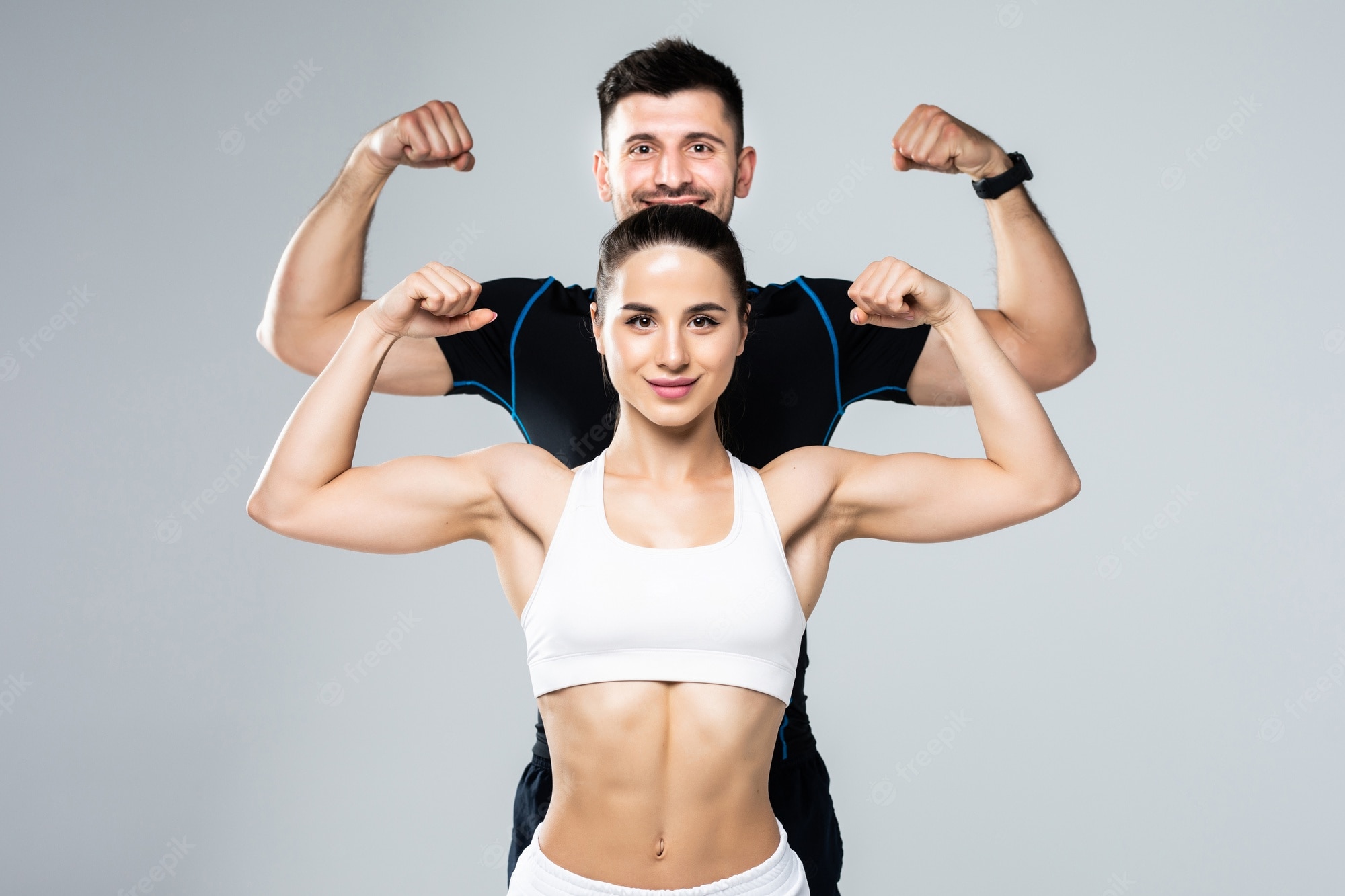 beautiful-athletic-couple-show-biceps-gray-background_264277-1279 beautiful-athletic-couple-show-biceps-gray-background_264277-1279